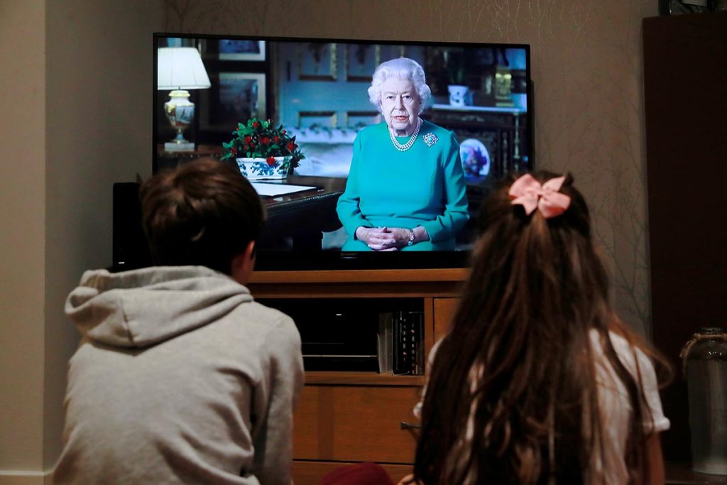 Noah (9) and Milly (7) watch Britain's Queen Elizabeth II during a televised address to the nation at their home, as the spread of the coronavirus disease (COVID-19) continues, Hertford, Britain, April 5, 2020.