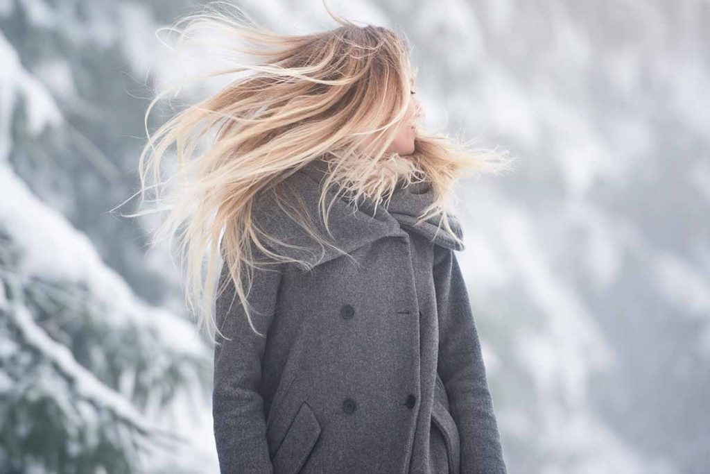 Beautiful young woman on a walk in winter nature