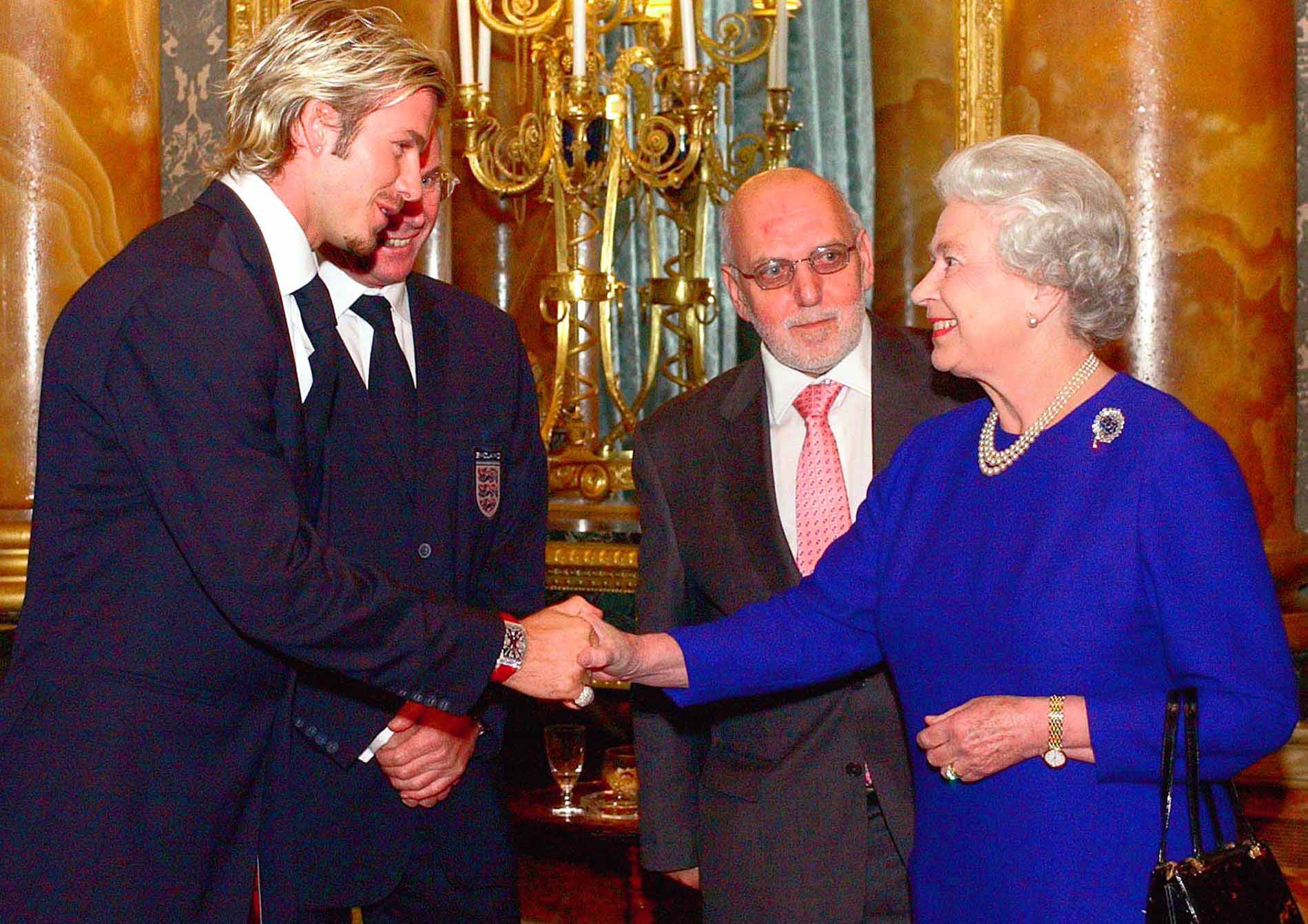 Britain's Queen Elizabeth II meets England soccer captain David Beckham, watched by English Football Association Chairman Geoffrey Thompson, and England coach Sven Goran-Ericsson, partly hidden, during a reception for the Football Association held at Buckingham Palace in London, Tuesday Nov. 19, 2002. The 75-strong England party included backroom staff as well as high profile players and management.(AP Photo/Kirsty Wigglesworth/pool)