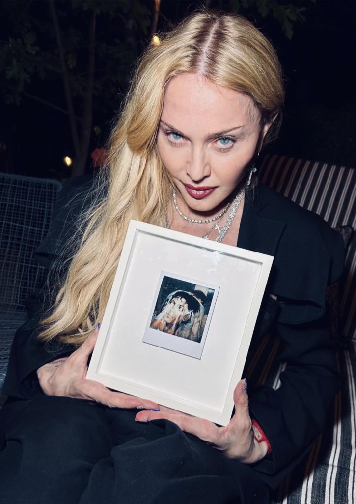 Madonna sosteniendo un cuadro.