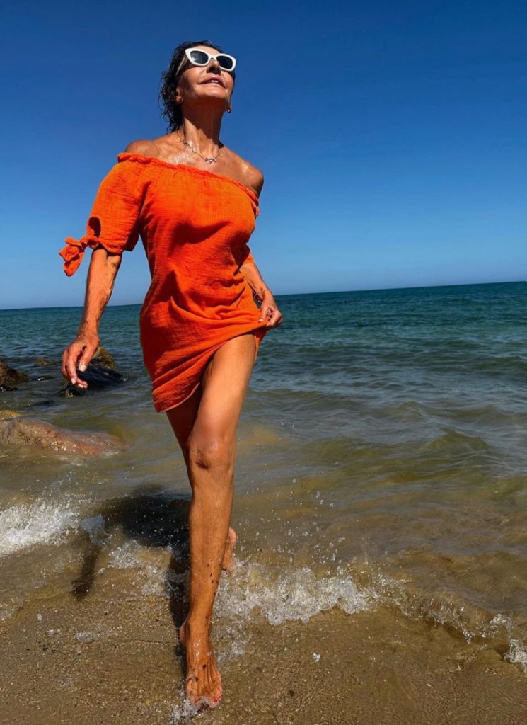 Naty Abascal con el vestido naranja vitamina luciendo piernas 