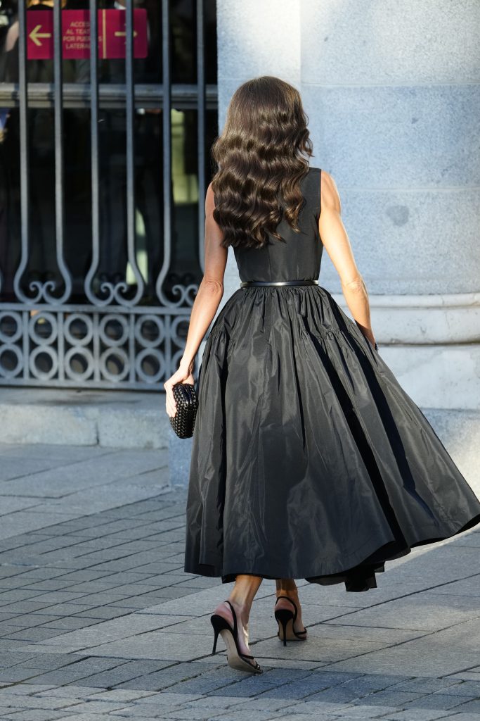 La Reina Letizia, de espaldas y con vestido negro entrando al Teatro Real.
