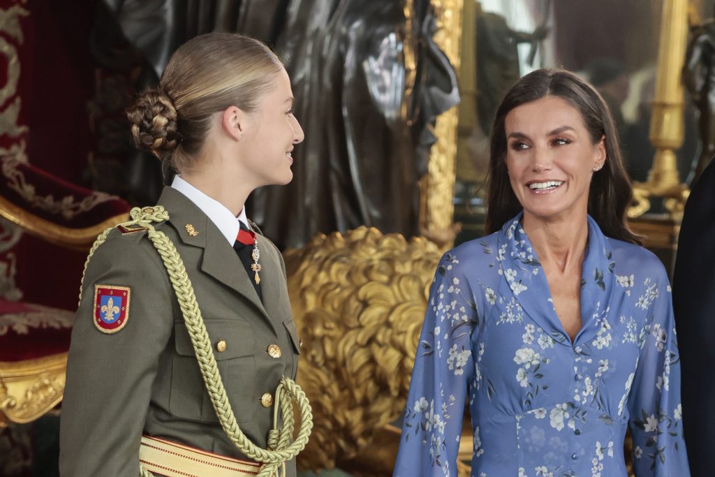 Leonor y Letizia, sonriendo y mirándose sonrientes en la Fiesta Nacional
