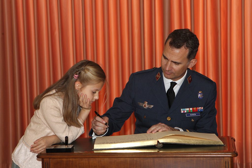 La Princesa Leonor observa cómo firma su padre en la Academia General del Aire en 2014