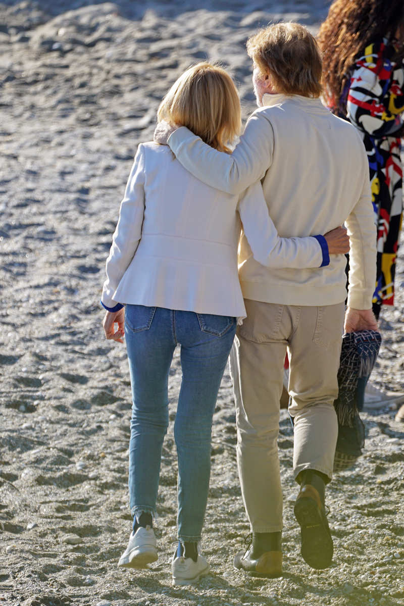 Bigote Arrocet paseando por la playa con una mujer