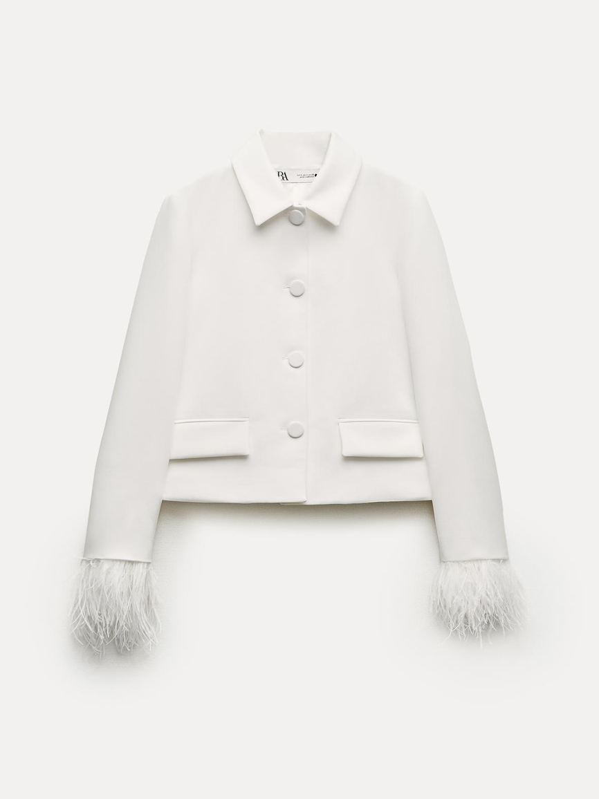 Esta blazer blanca con plumas en las mangas transmite originalidad y elegancia