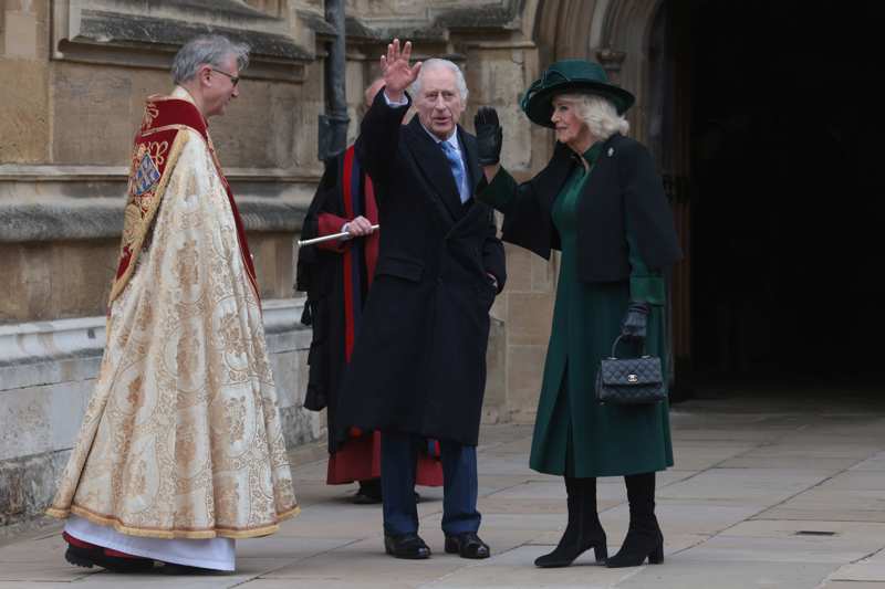 Los Reyes británicos saludando a los medios en compañía del cura que ha oficiado la misa de Pascua.