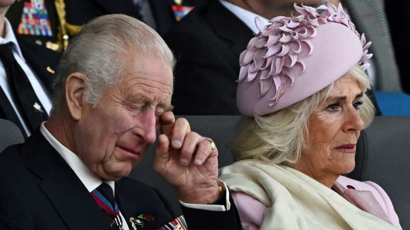 El Rey Carlos III llorando, se seca las lágrimas. 