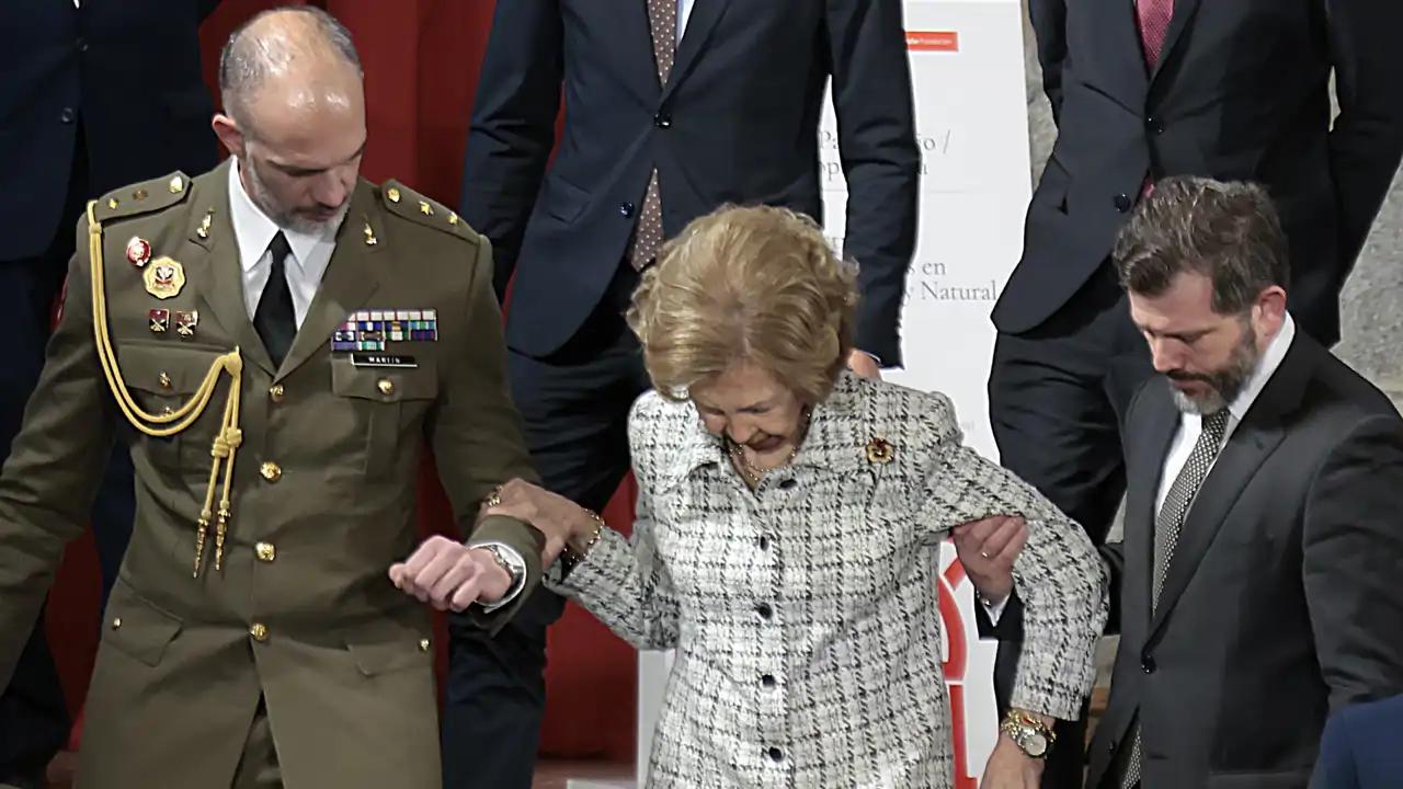 La Reina Sofía, ayudada por su equipo durante su último acto oficial