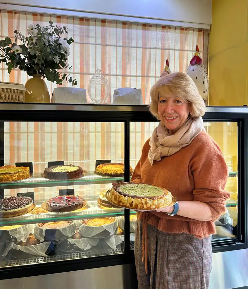 Pilar Molina en una de sus tiendas sujetando la famosa tarta de queso y pistacho en sus manos.