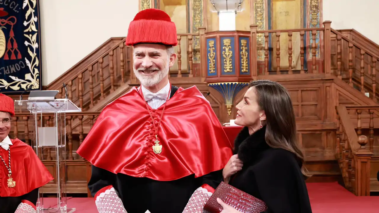 La Reina Letizia mira emocionada al Rey Felipe VI que sonríe feliz con la toga y el birrete.