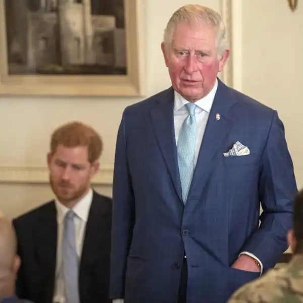 El rey Carlos III y su hijo menor, el príncipe Harry, al fondo