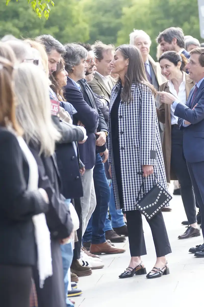 La Reina Letizia visita la Cuesta de Moyano con el trench de cuadros más versátil y súper tendencia