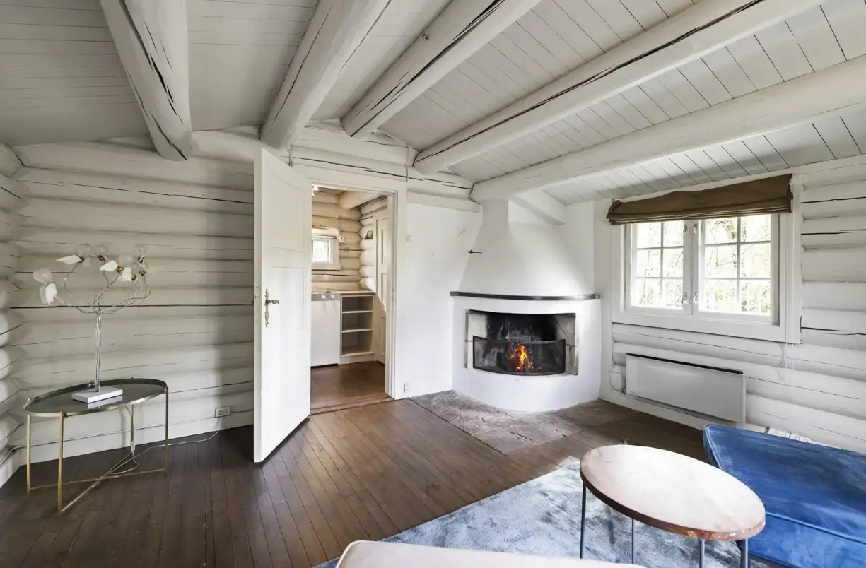 Una pequeña casa de madera con chimenea.