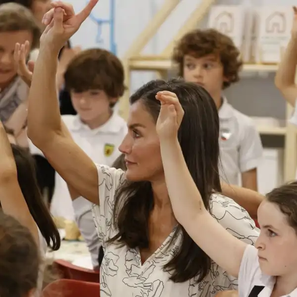 La Reina Letizia pidiendo la vez rodeada de niños