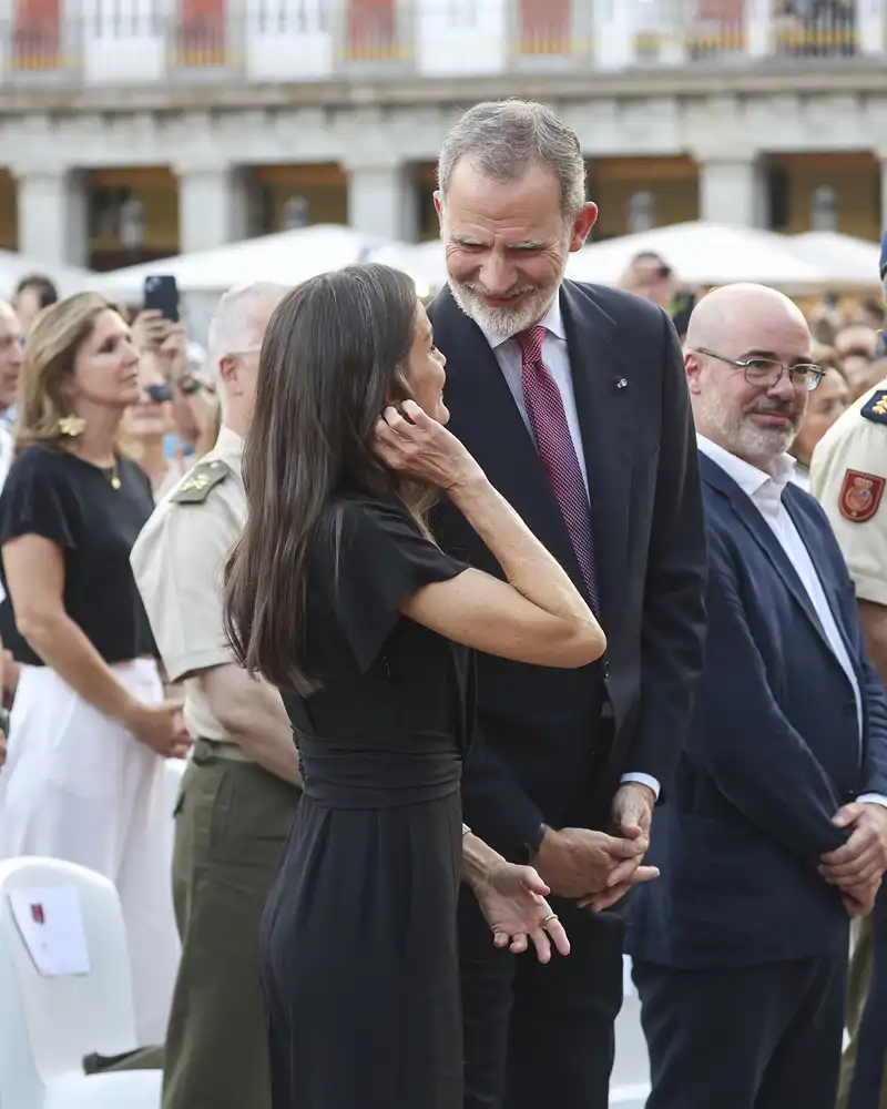 Los Reyes Felipe y Letizia hablando con gestos sonrientes