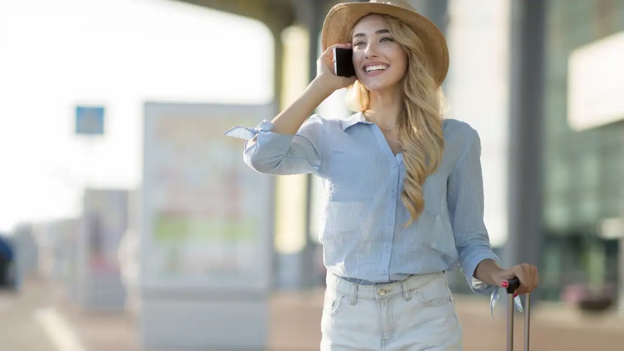Chica en el aeropuerto con móvil iStock