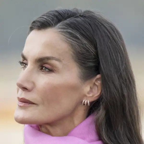 La Reina Letizia de ha decantado por un abrigo gris, de hombreras marcadas, corte 'lady' con un estampado floral en un tono rosa, a juego con su pashmina.