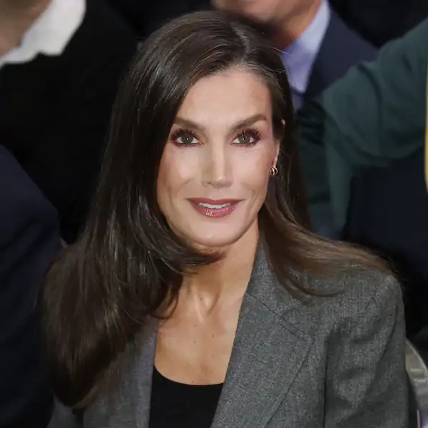 La Reina Letizia, sonriente con traje gris durante el acto organizado por la Fundación Microfinanzas BBVA