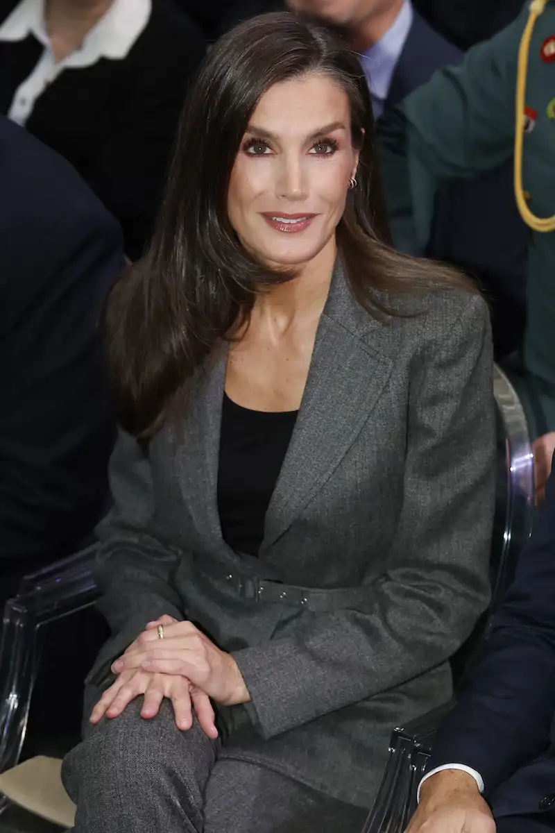La Reina Letizia, sonriente con traje gris durante el acto organizado por la Fundación Microfinanzas BBVA