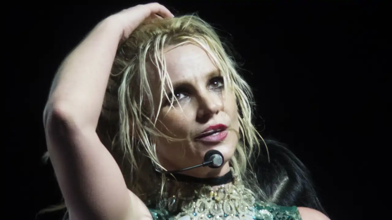 Britney Spears mặc đồ màu xanh lá cây trong một buổi hòa nhạc.