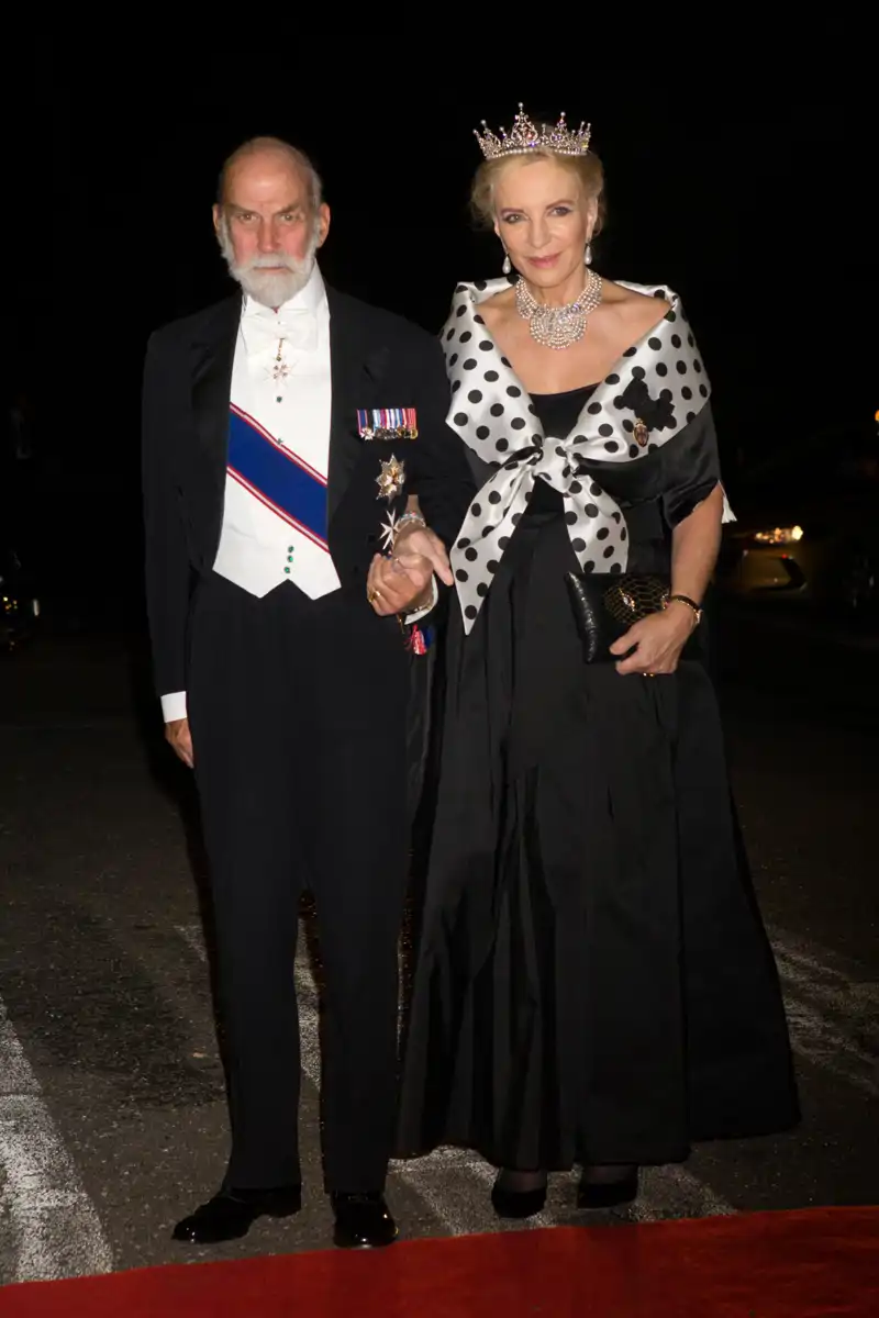Michael de Kent junto a su marido, con tiara y un vestido negro con pañuelo de topos