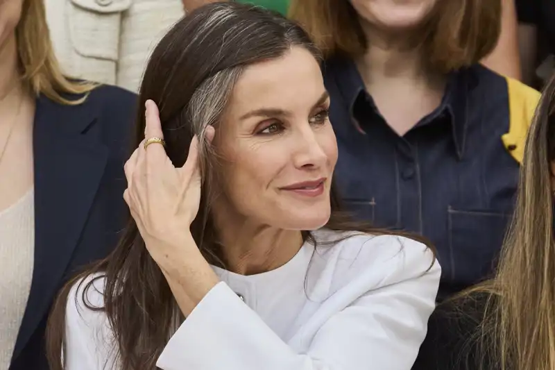 La Reina Letizia se lleva la mano al cabello durante un acto institucional