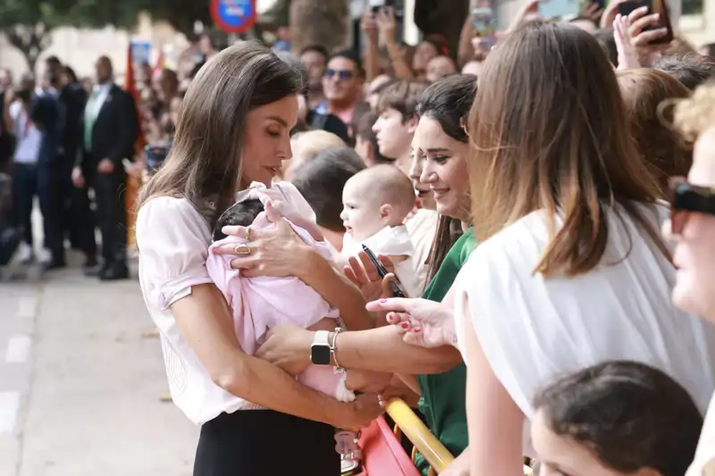 La Reina Letizia coge en brazos a un bebé durante su paso por Melilla